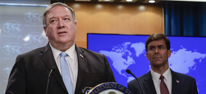 Secretary of State Mike Pompeo speaks as Defense Secretary Mark Esper listens, during a joint briefing, Thursday, June 11, 2020 at the State Department in Washington, on an executive order signed by President Donald Trump aimed at the International Crimin