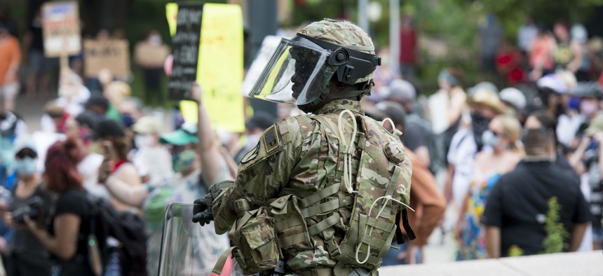 A military police officer assigned to the Texas National Guard watches over protesters during a peaceful demonstration in Austin, Texas, May 31, 2020. 