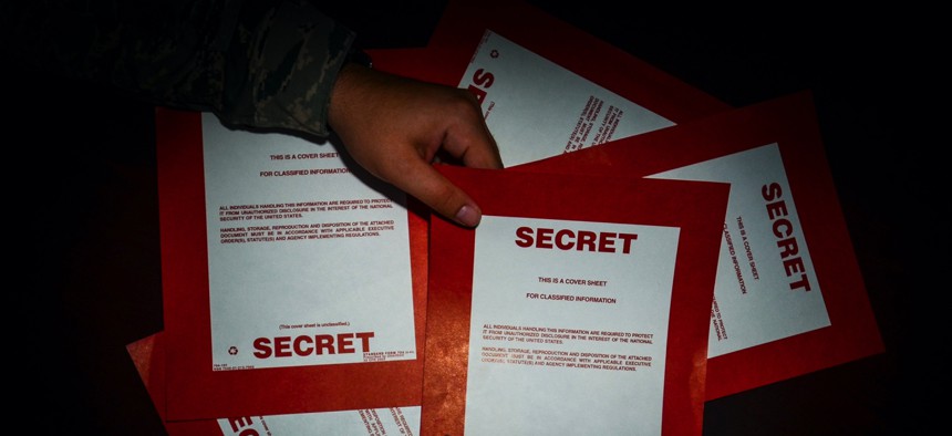 Secret cover sheets are handled by an intelligence analyst with the 169th Operations Support Squadron at McEntire Joint National Guard Base, S.C., in 2015.