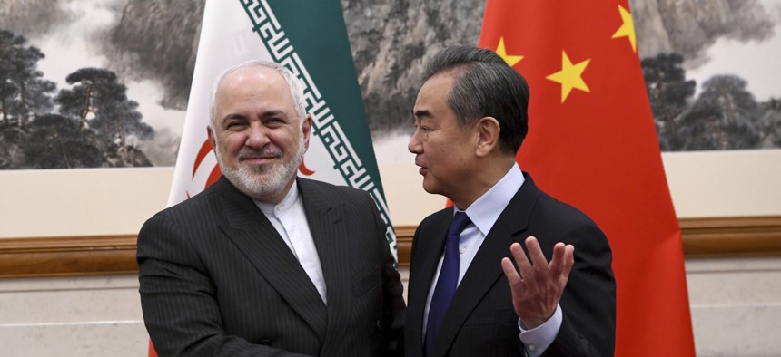 China's Foreign Minister Wang Yi, right, shakes hands with Iran's Foreign Minister Mohammad Javad Zarif during a meeting at the Diaoyutai state guest house in Beijing Tuesday, Dec. 31, 2019.