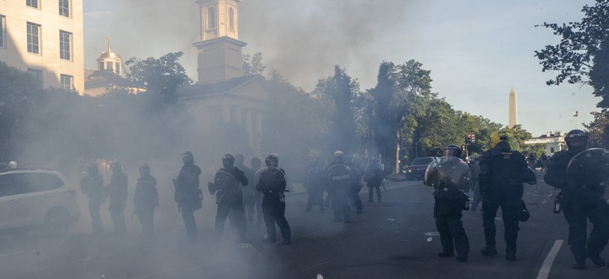  In this June 1, 2020 file photo police move demonstrators away from St. John's Church across Lafayette Park from the White House, as they gather to protest the death of George Floyd in Washington. 