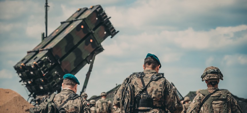 Service members from the U.S. Army and the Polish Land Forces walk to the site of the new Patriot missile system for a verbal demonstration of its operation and capabilities near Drawsko Pomorskie, Poland, June 4, 2018.