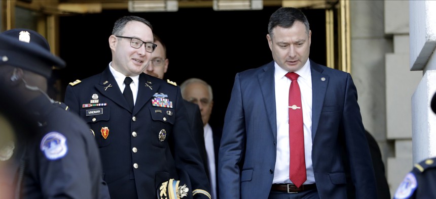 then National Security Council aide Lt. Col. Alexander Vindman, left, walks with his twin brother, Army Lt. Col. Yevgeny Vindman, after testifying before the House Intelligence Committee on Capitol Hill in Washington