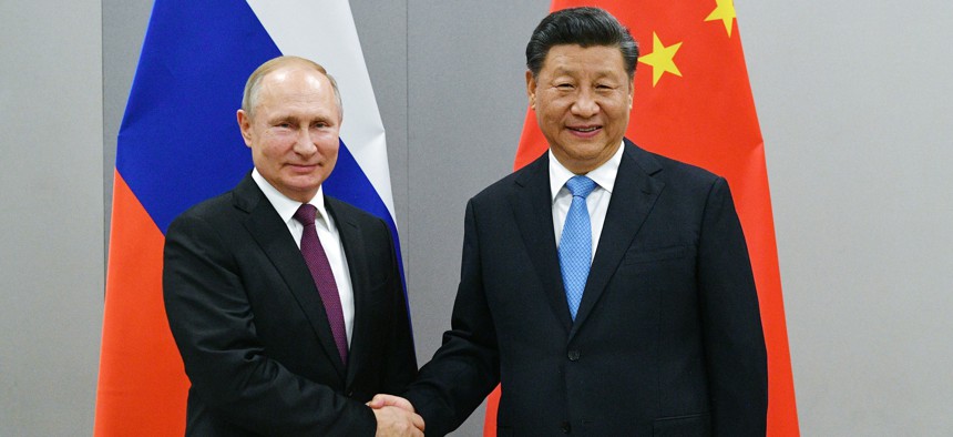 Russian President Vladimir Putin, left, and China's President Xi Jinping shake hands prior to their talks in Brasilia, Brazil, Wed., Nov. 13, 2019.