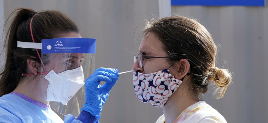 Heather Brown, right, is tested for COVID-19 at a new walk-up testing site at Chief Sealth High School, Friday, Aug. 28, 2020, in Seattle.