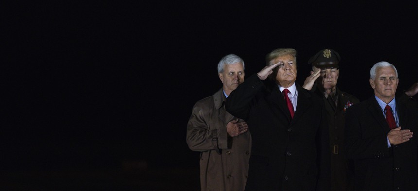 President Donald Trump watches as a U.S. Army carry team salutes the transfer cases containing the remains of service members killed during combat in Afghanistan in February. 