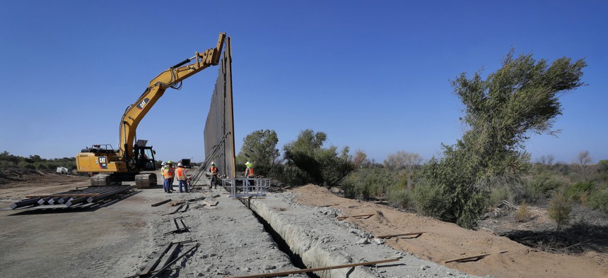 Government contractors erect a section of Pentagon-funded border wall along the Colorado River, in Yuma, Ariz., in November 2019.