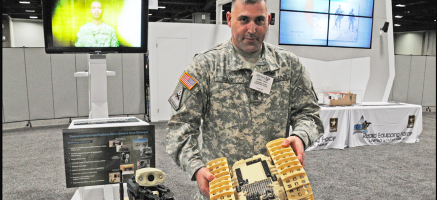 Sgt. Maj. James Hash shows a Rapid Equipping Force-procured Dragon Runner, operated by Soldiers remotely in Afghanistan for reconnaissance and counter improvised explosive device operations. The venue is the Washington Auto Show, in February 2013.