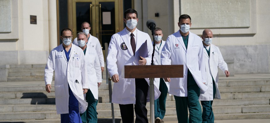 Dr. Sean Conley, physician to President Donald Trump, center, and other doctors, walk out to talk with reporters at Walter Reed National Military Medical Center, Monday, Oct. 5, 2020, in Bethesda, Md.
