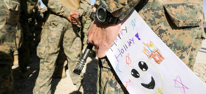 A Marine in Afghanistan holds a holiday card received from a grade school in Maryland, Dec. 22, 2018.