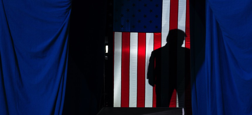 The shadow of President Donald Trump falls on a flag Feb. 20, 2020, in Colorado Springs, Colo.