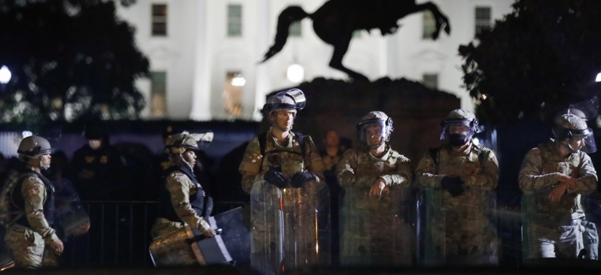 A line of DC National Guard members stand in Lafayette Park as demonstrators gather to protest the death of George Floyd, Tuesday, June 2, 2020, near the White House in Washington. Floyd died after being restrained by Minneapolis police officers.