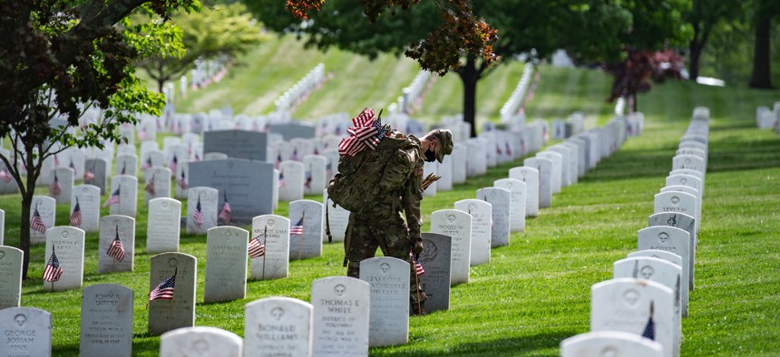 Soldiers assigned to the 3rd U.S. Infantry Regiment, known as “The Old Guard,” place American flags at headstones in Arlington National Cemetery, Arlington, Va., May 21, 2020. 