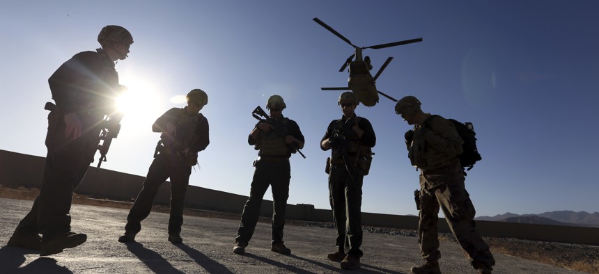 American soldiers wait on the tarmac in Logar province, Afghanistan. The U.S. is pausing movement of troops into Afghanistan and quarantining 1,500 new arrivals to country due to virus.