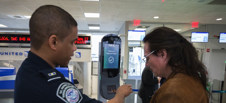 A U.S. Customs and Border Protection officer directs a passenger to submit to biometric facial recognition photos at Houston International Airport in 2018.