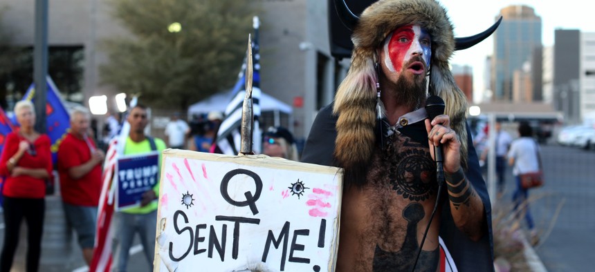 A Qanon believer speaks to a crowd of President Donald Trump supporters outside of the Maricopa County Recorder's Office where votes in the general election are being counted, in Phoenix, on Nov. 5, 2020. 