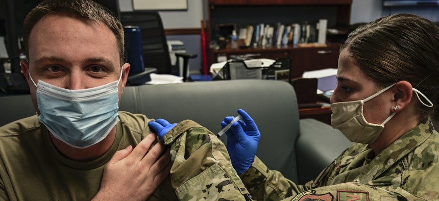 Senior Airman Kara Sweeney, 911th Aeromedical Staging Sqadron aeromedical technician, administers an influenza vaccination to Tech. Sgt. Richard Kaulfers, 911th Airlift Wing broadcast journalist,