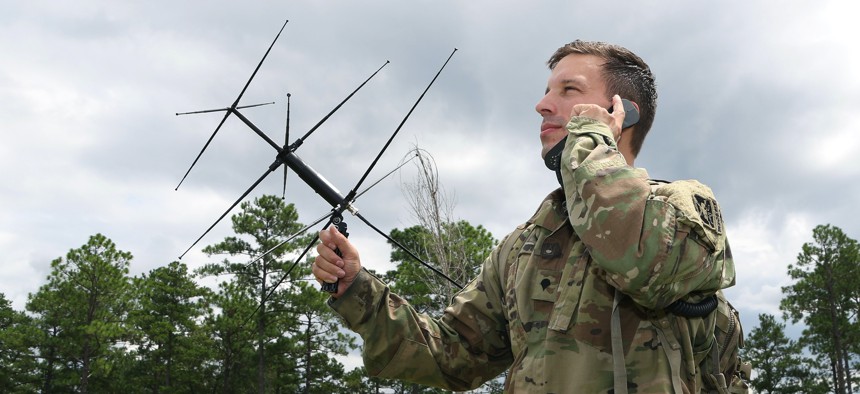 A student in the Special Forces Communications Sergeant course uses an AV-2125 satellite antenna with an AN/PRC-117G satellite radio during training. 