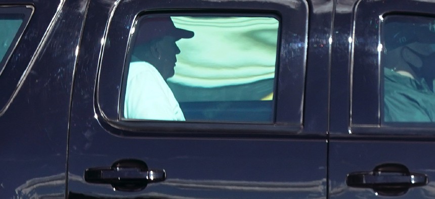 President Donald Trump rides in a motorcade vehicle as he departs Trump International Golf Club, Sunday, Dec. 27, 2020, in West Palm Beach, Fla. 