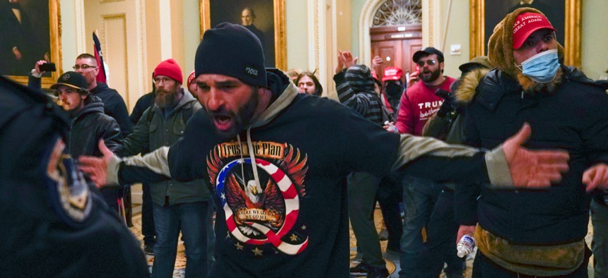 Trump supporters gesture to U.S. Capitol Police in the hallway outside of the Senate chamber at the Capitol in Washington, Wednesday, Jan. 6, 2021. 