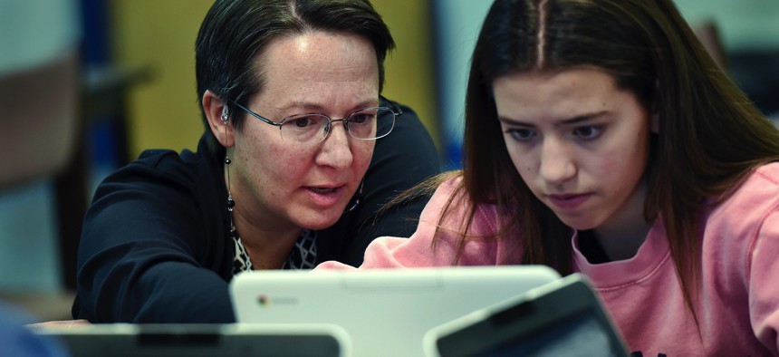 A teacher librarian at Brookfield, Conn., High School works with a freshman in her Digital Student class, a required course in which students learn to evaluate online information.