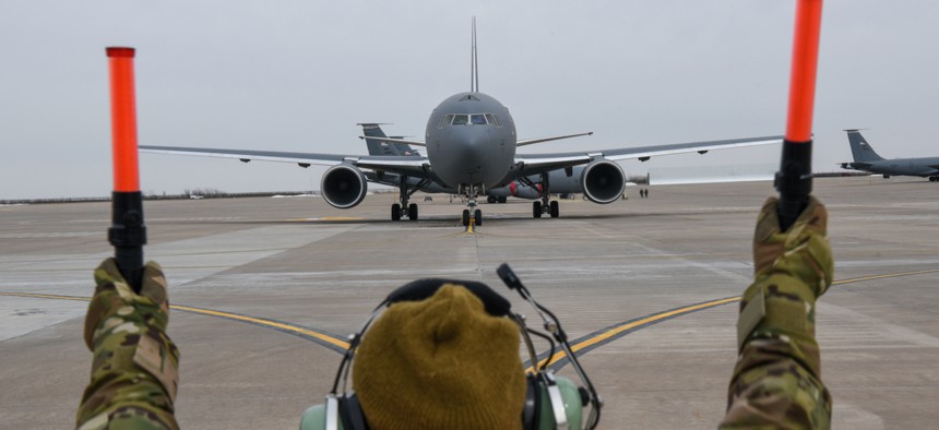 A crew chief marshals a KC-46A Pegasus on the flightline at McConnell Air Force Base in Kansas.