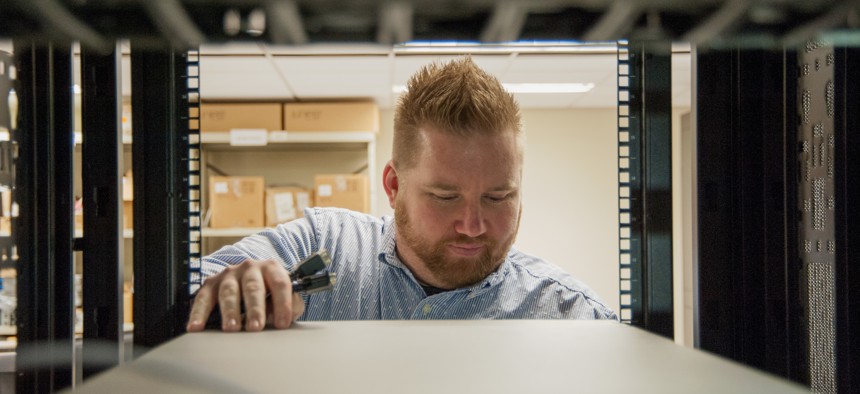 Brandon Simpkins, lead network engineer at Space and Naval Warfare Systems Center Atlantic, examines server operations. Simpkins completed a fellowship at Amazon Web Services.