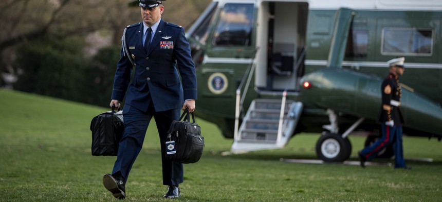 A U.S. military aide carries the "president's emergency satchel," also know as "the football," with the nuclear launch codes, across the South Lawn of the White House.