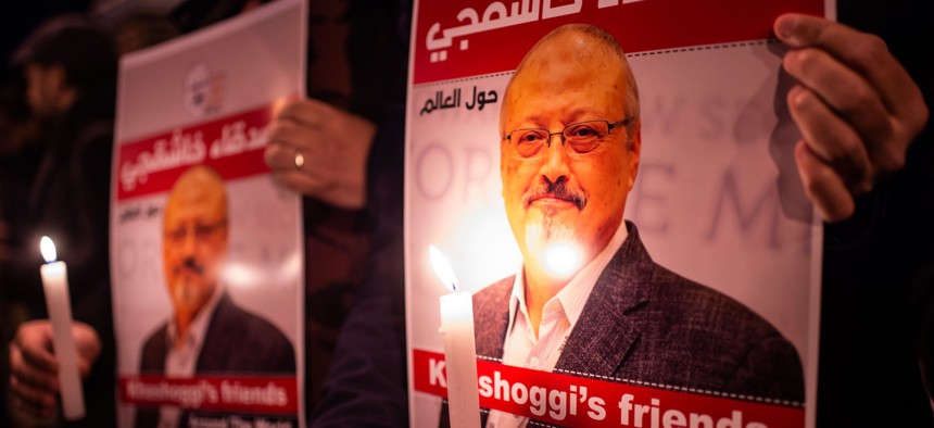 People hold posters picturing Saudi journalist Jamal Khashoggi and lightened candles during a gathering outside the Saudi Arabia consulate in Istanbul, on October 25, 2018.