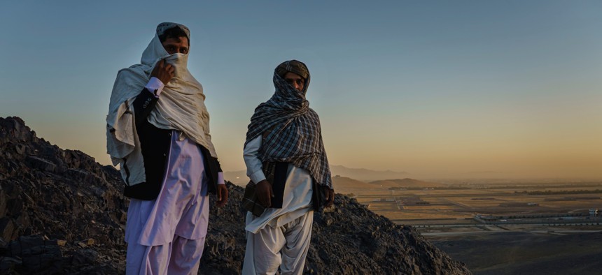 Rohullah Salhe, 35, former Taliban member and former prisoner, left, and Jumah Gul, 40, right, a Taliban commander, stand in the mountains on the outskirts of Kandahar, Afghanistan, on Monday Oct. 26, 2020.