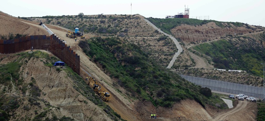 In this March 11, 2019, file photo, construction crews replace a section of the primary wall separating San Diego, above right, and Tijuana, Mexico, below left, seen from Tijuana, Mexico. 