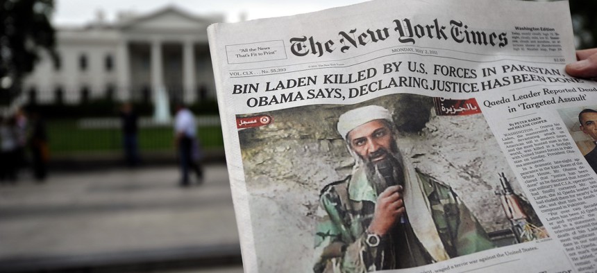 A man reads the front page of a newspaper featuring a picture of Al-Qaeda leader Osama bin Laden, in front of the White House in Washington, DC, on May 2, 2011
