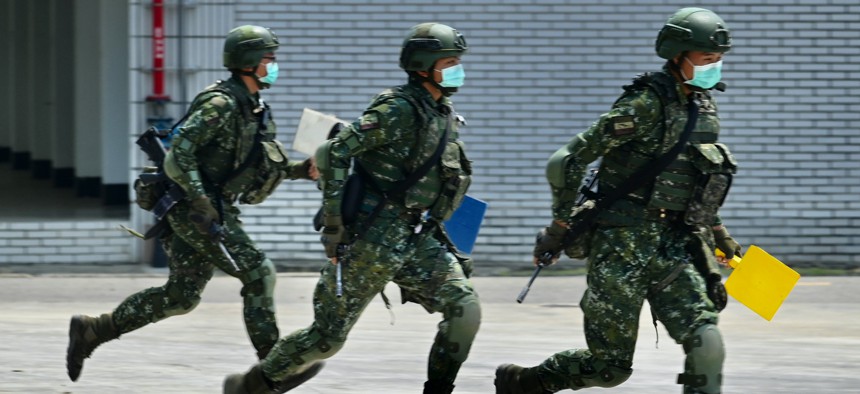 Soldiers wearing face masks amid the COVID-19 coronavirus pandemic take part in a drill during Taiwan President Tsai Ing-wen's visit to a military base in Tainan, southern Taiwan, on April 9, 2020.