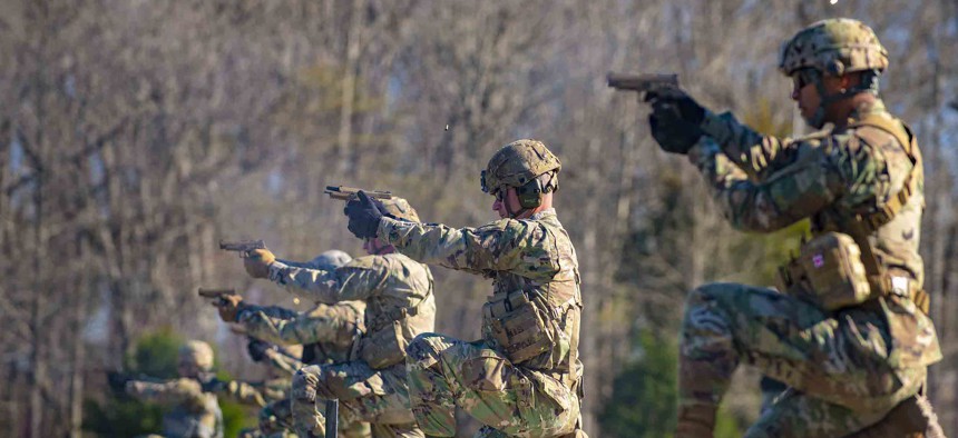 Soldiers fire M17 semi-automatic pistols during the 2021 Fort Knox and First Army Division East Best Warrior Competition at Fort Knox, Ky., March 29, 2021.