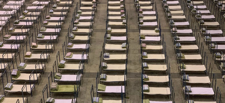 Workers set up beds at an exhibition centre that was converted into a hospital in Wuhan in China's central Hubei province on February 4, 2020.