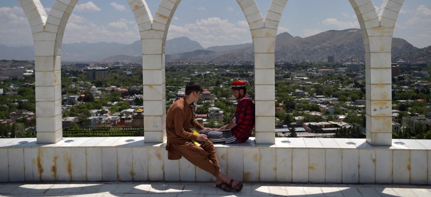 Youths sit at the Wazir Akbar Khan hilltop overlooking Kabul on May 11, 2021.
