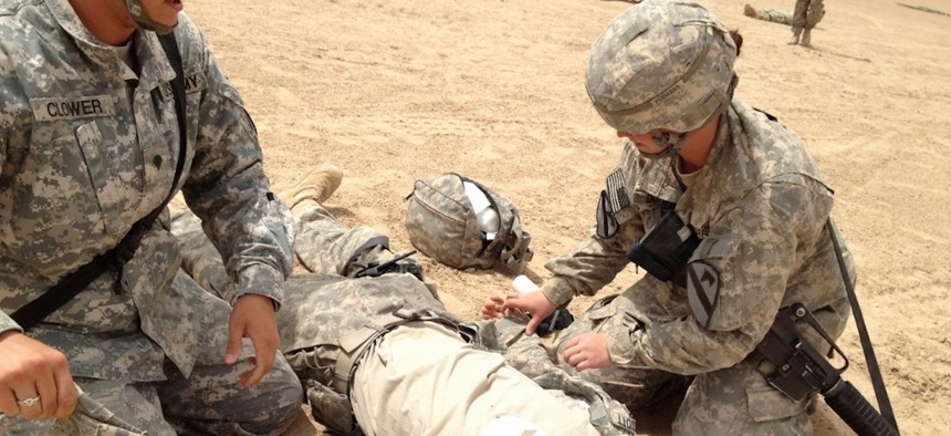 Spc. Melinda Clower (left) and Spc. Lacey Duffy (right), soldiers assigned to Company C, 115h Brigade Support Battalion, 1st Brigade Combat Team, 1st Cavalry Division, evaluate and treat Spc. Scott Ehrgott (center) during a company field training exercise, April 5.