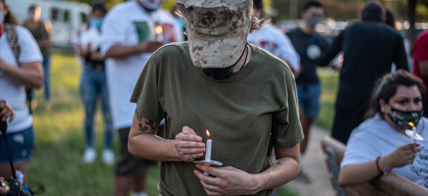 Jennifer Massucci, a former Marine, holds a lit candle at a march and vigil for murdered Army Spec. Vanessa Guillen on July 12, 2020 in Austin, Texas.