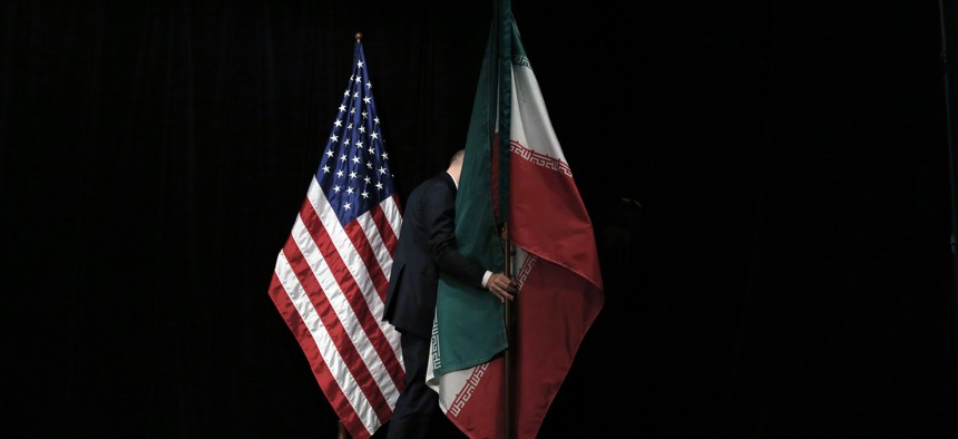 A staff removes the Iranian flag from the stage after a group picture with foreign ministers and representatives of Unites States, Iran, China, Russia, Britain, Germany, France and the European Union during the Iran nuclear talks at Austria International Centre in Vienna, Austria on July 14, 2015.