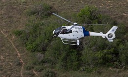 A Customs and Border Protection Air and Marine Operations agent patrols in an EC120 helicopter checking from the air for border crossers, drug smugglers and any other illegal activities along the Laredo, Texas border.