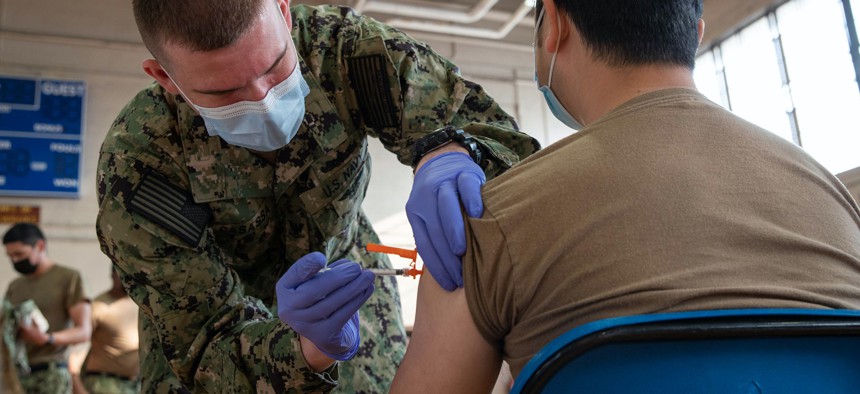Hospital Corpsman 3rd Class Joseph Casassa administers a COVID-19 vaccine to Logistics Specialist Seaman Rix Zhang at Naval Station Norfolk, April 8, 2021. 