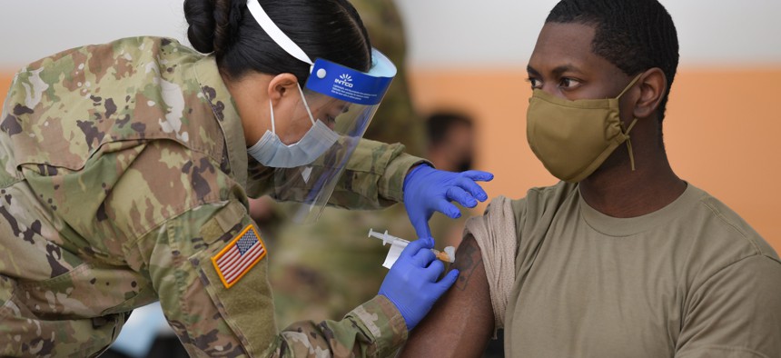U.S. Army Spc. Eyza Carrasco, left, with 2nd Cavalry Regiment, administers a COVID-19 vaccination at the 7th Army Training Command’s Rose Barracks, Vilseck, Germany, May 3, 2021. 