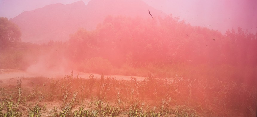 Pink smoke marking the landing zone, an Army medevac helicopter touches down in Kandahar in 2011 to pick up several wounded soldiers.