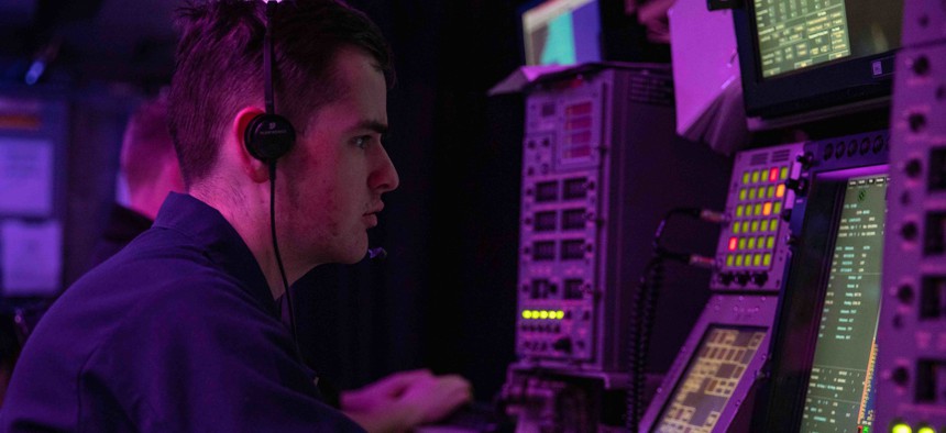 As part of Large Scale Exercise 2021, U.S. Navy Operations Specialist 3rd Class Jack Azzopardi tracks surface vessels in the combat information center aboard the San Antonio-class amphibious transport dock Arlington on Aug. 8, 2021.