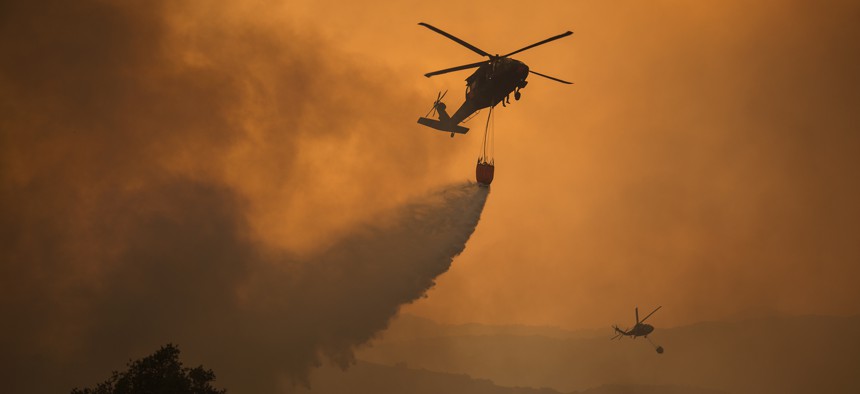 National Guard helicopters drop water on the 2017 Thomas Fire near Ojai, California. 