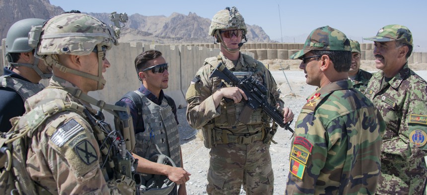 Sgt. 1st Class Jeremiah Velez, left, and Capt. David Zak, center, both advisors with the 1st Security Force Assistance Brigade's 3rd Squadron, speak with their Afghan National Army counterparts during a fly-to-advise mission at Forward Operating Base Altimur, Afghanistan, Sept. 19, 2018. 