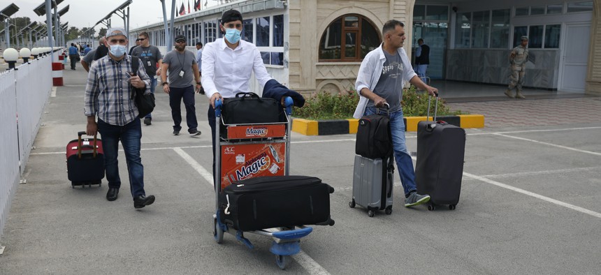 Passengers walk from the domestic terminal at Hamid Karzai International Airport in Kabul, Afghanistan, Saturday, Aug. 14, 2021.