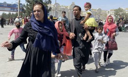 An Afghan family rushes to the Hamid Karzai International Airport as they flee the Afghan capital of Kabul, Afghanistan, on August 16, 2021. 