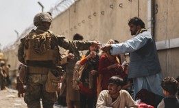 A Marine with the 24th Marine Expeditionary unit (MEU) passes out water to evacuees during an evacuation at Hamid Karzai International Airport, Kabul, Afghanistan, Aug. 22.