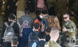 A U.S. Air Force airman guides qualified evacuees aboard a U.S. Air Force C-17 Globemaster III in support of the noncombatant evacuation operation at Hamid Karzai International Airport, Afghanistan, Aug. 24, 2021. 